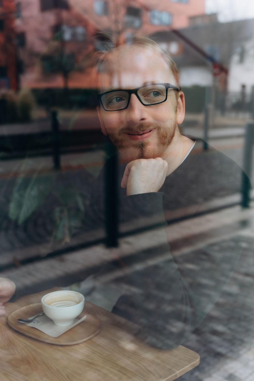 Šimon Podhajský, seen through a café window in Prague